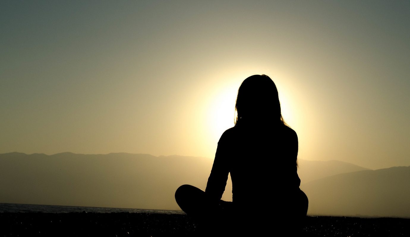 Girl Meditating Against Sunset