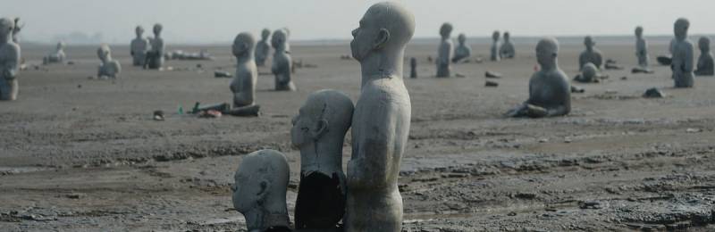 Statues Submerged In Mud