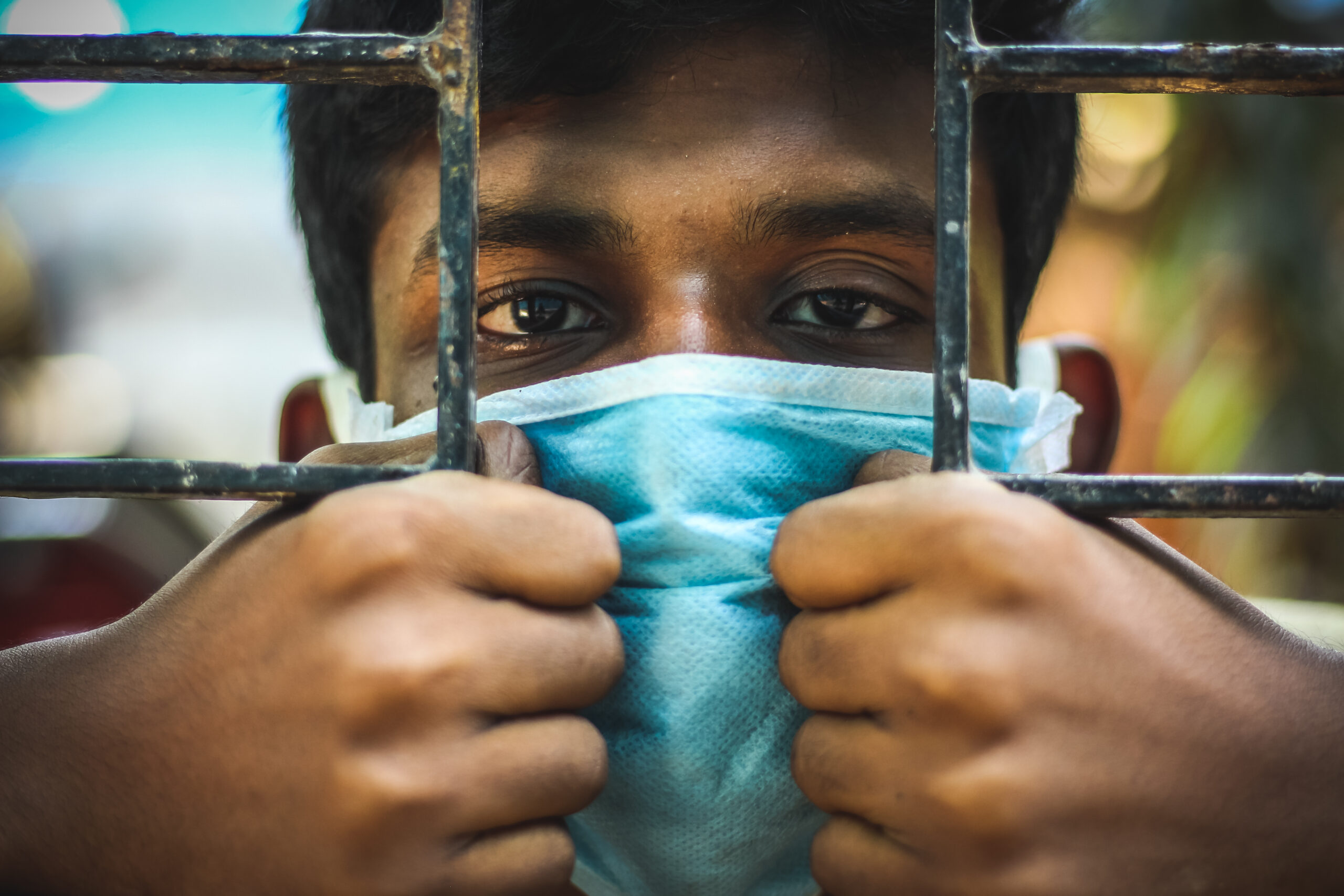 Lockdown peoples for quarantine.Protection against contagious disease, coronavirus. Man wearing hygienic mask to prevent infection, airborne respiratory illness such as flu, 2020. Outdoor shot isolated on blue background. Asian young man have a cold and wearing blue mask